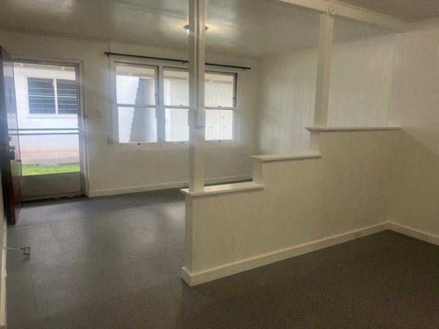 an empty room with a staircase and two windows